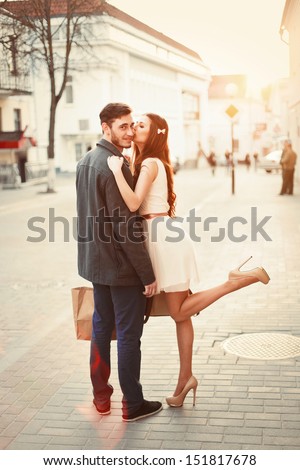 Young happy funny couple lovely posing and kissing outdoor. Handsome man have a gift for his girlfriend. Summer or autumn outdoor portrait.