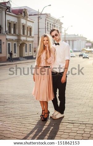 Young fashion couple posing outdoor in summer. Handsome man and pretty beautiful woman outdoor vintage portrait.