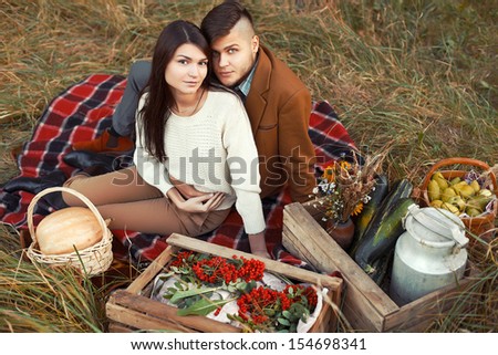 Young beautiful fashion couple in love having fun outdoor in autumn. Cute brunette sensual woman posing with her handsome man outdoor.