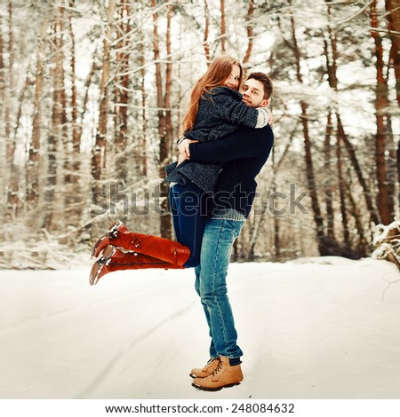 Outdoor happy nice colorful fashion portrait of pretty young beautiful couple posing in winter forest