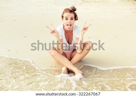 Pretty young smiling happy woman posing outdoor on the beach having fun on yellow sand seashore
