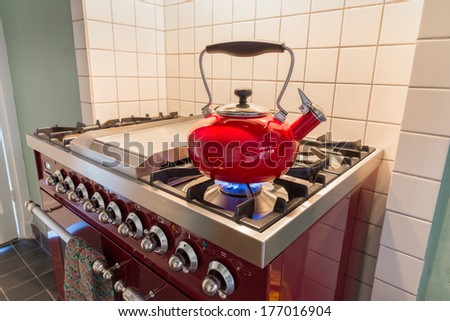 Red kettle heating up on the stove