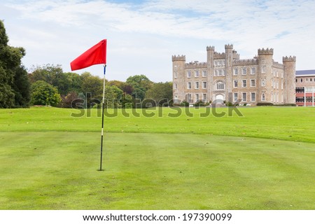 GORMANSTON, IRELAND - SEPTEMBER 29, 2013: Red golf flag on the Gormanston College golf course with the castle in the background.