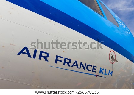 AMSTERDAM - 19 JULY, 2014: The Air France KLM company name written on a Cityhopper Fokker 70 with reflection of boarding travellers.