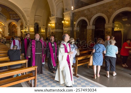 LOURDES - JULY 23, 2014: Priests in the Basilique de Notre Dame de l\'Immaculee Conception de Lourdes. From April to October, the International Mass takes place every Wednesday and Sunday.