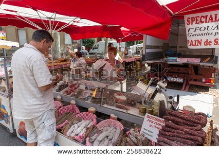 TOULOUSE, FRANCE - JULY 27, 2014: A vendor selling meats at the March Saint Aubin, the Saint Aubin Market, in Toulouse. Marche Saint Aubin is only held on Sundays.