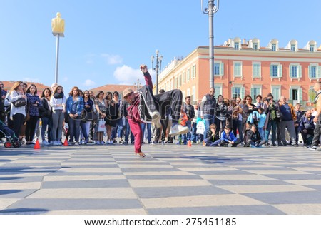 NICE, FRANCE Ã¢?? APRIL 11, 2015: A group of street dancers performing a break dance routine on Place Massena in Nice, France.