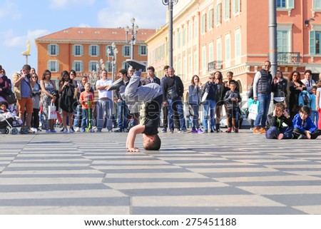 NICE, FRANCE Ã¢?? APRIL 11, 2015: A group of street dancers performing a break dance routine on Place Massena in Nice, France.