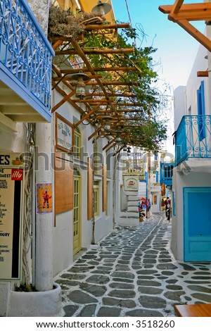 tight alley way of mykonos detailing the white wash walls and blue trim