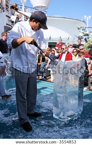 Ice carver sculpting a design in front of a crowd on a cruise liner
