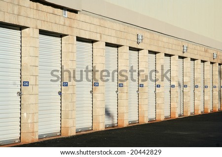 Self storage warehouse metal roll up doors closed in a row.
