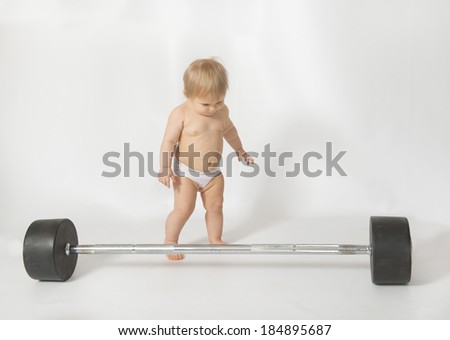 Little girl meets a big barbell on white background