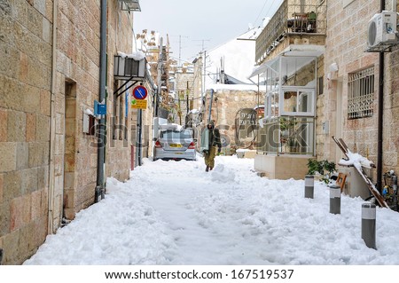 Soldier walking down the street of Jerusalem covered in snow, December 13,2013