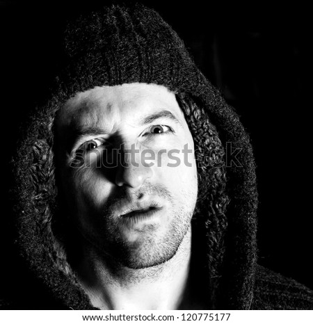angry violent man with hood up staring