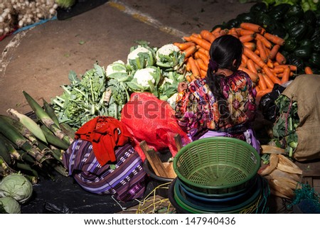 CHICHICASTENANGO, GUATEMALA- MAY 9: An unidentified woman sells vegetables at traditional weekly market in Chichicastenango (Chichi), Guatemala on 9 May 2013