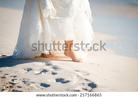 Closeup of bare feet of a bride on the beach in Mexico, Riviera Maya. Destination wedding.