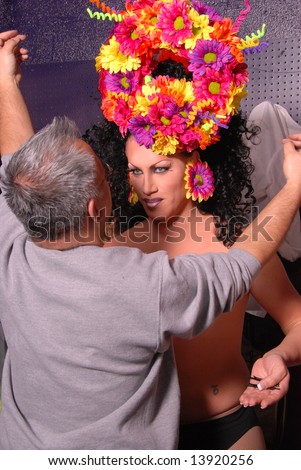 Drag queen having her hair done by an un-identifiable man before a show.