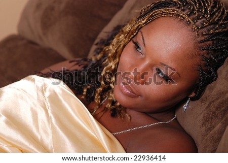 Portrait of a beautiful African American woman wrapped in a gold satin sheet.