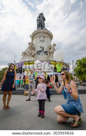 PARIS, FRANCE   AUGUST 7, 2015: A little girl and friend release their balloons at an anti-nuclear demonstration on the 70th anniversary of the bombing of Hiroshima and Nagasaki.