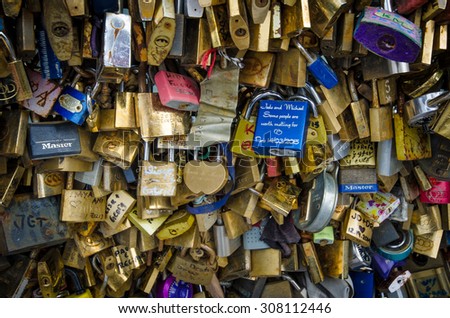 PARIS, FRANCE - AUGUST 15, 2015: Hundreds of locks left by lovers with their names adorn the side of Pont Saint-Louis behind Notre-Dame Cathedral connecting Ile de la Cite and Ile Saint-Louis.