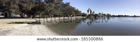 Beautiful panorama of the Leschenault Estuary Bunbury Western Australia  on a sunny afternoon in late summer  with  casuarina trees offering shade in a little park   where the estuary ends.