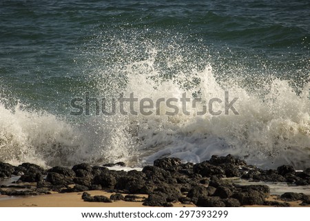 Spectacular backwash from the  Indian Ocean waves breaking on basalt rocks at  Ocean Beach Bunbury Western Australia on a sunny  morning in  winter  sends salty spray high into the air.