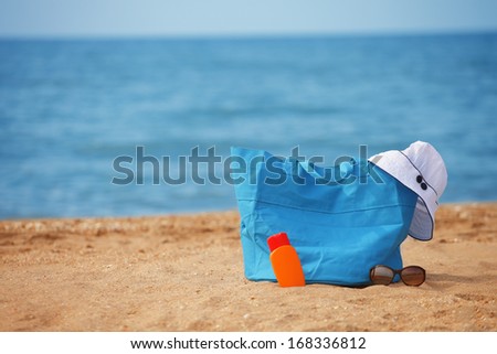 a photo of Packed beach bag on empty sand beach