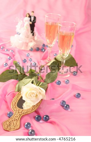 a photo of wedding cake dolls, rose and glasses over pink