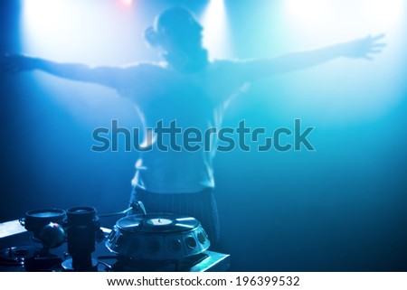 Dj man with headphones playing on vinyl in a nightclub