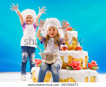Children are happy and laughing near a huge cake with roses