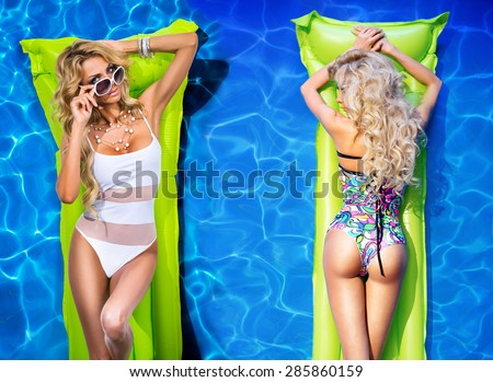 Two girls floating on mattresses in the pool
