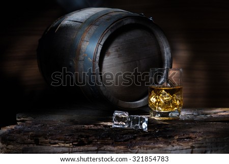 Keg and a glass of whiskey on a wooden table