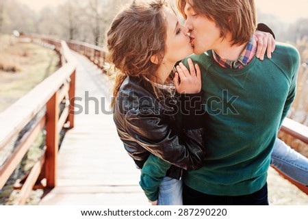 happy young loving couple kissing at outdoor walk