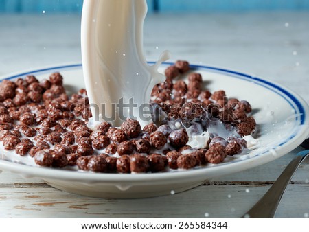 corn balls breakfast with milk being poured over it