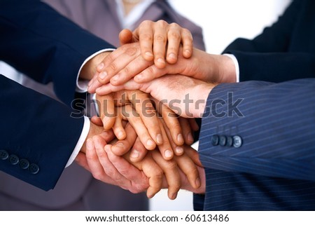 Closeup of business people\'s hands making a pile against a white background.