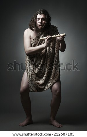 Primitive wild man learn to play music with flute.