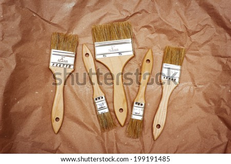 Set of five different renovation brushes on craft paper