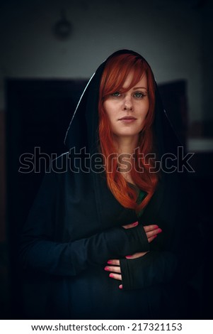 Dramatic portrait of beautiful red hair woman in black