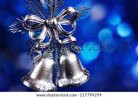 Christmas decoration with silver bells with blue blurred background