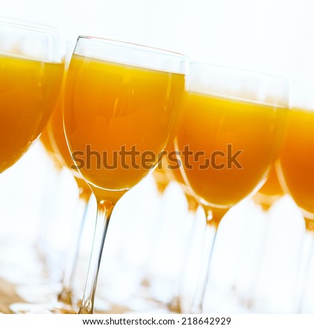 Fresh orange juice over white background. Square composition.