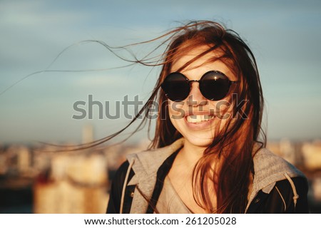Outdoor portrait of young woman in round sunglasses having fun outdoor in summer in the city
