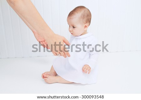 Beautiful baby with mother hands help on white background