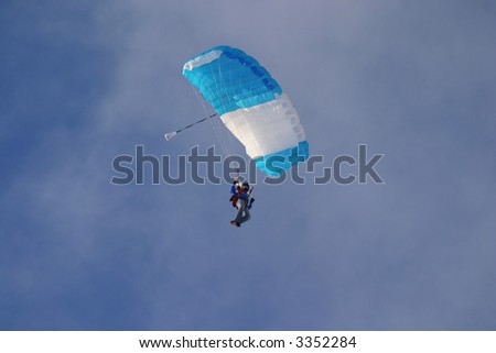 Man with opened para?hute in the sky after skydiving