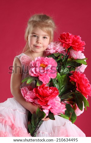 little girl dressed as a ballerina with a bouquet of peonies on a pink background