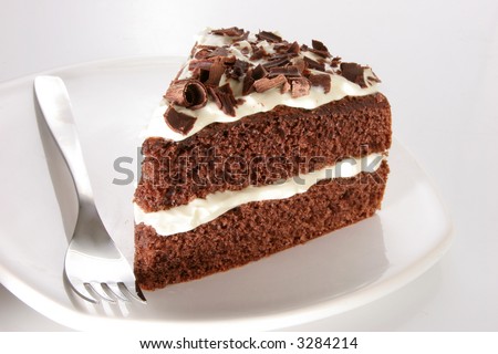 Slice of chocolate cake stuffed with whipped cream, covered with whipped cream and white chocolate on neutral background