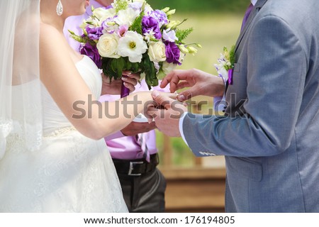 newlyweds holding hands Bride is holding in her hand a beautiful bouquet