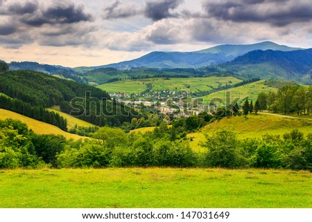 settlement on the pentagonal clearing away in the mountains near a formidable summer sky
