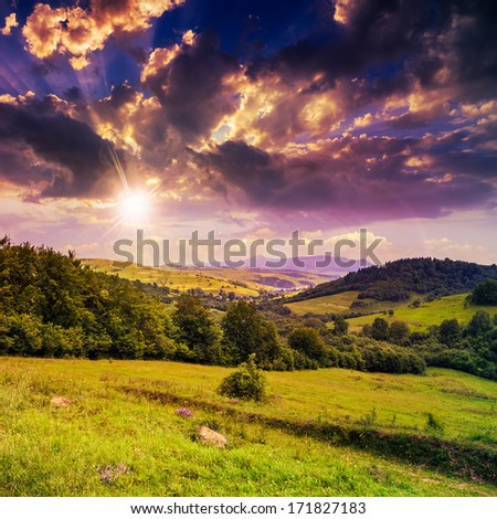 autumn landscape. village on the hillside. forest on the mountain. sun light fall on clearing on mountains