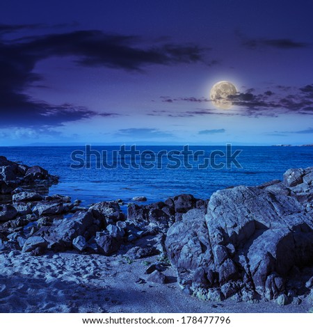 sea wave attacks the sandy beach and break on them at night in moon light