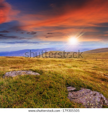 mountain landscape. valley with stones on the hillside. forest on the mountain under the beam of light falls on a clearing at the top of the hill at sunset